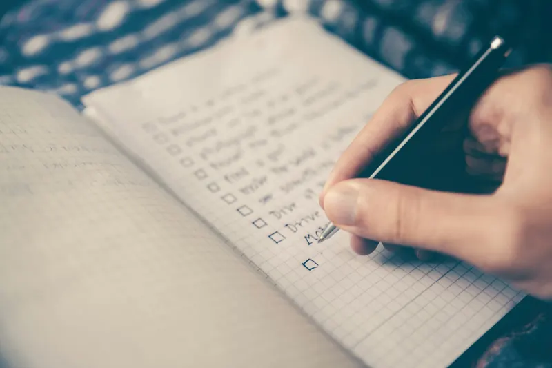 Monthly planner and calendar open on a desk with a pen for cash flow planning