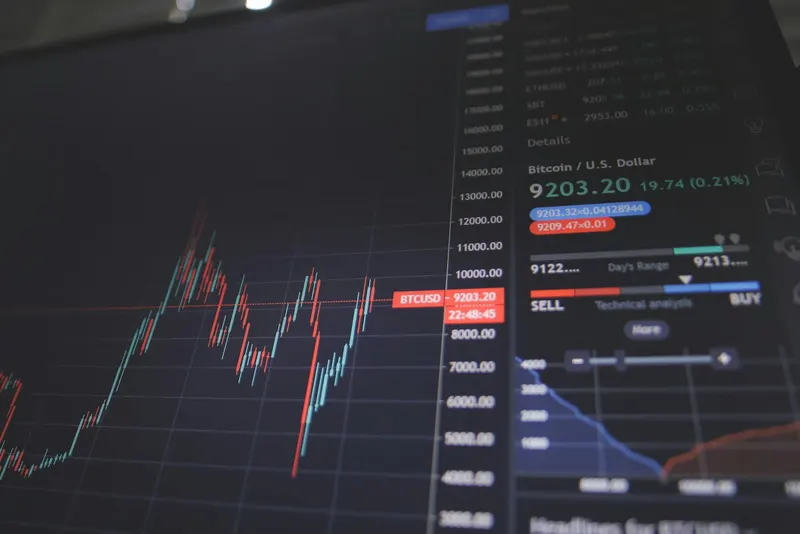 Person reviewing investment portfolio charts on a laptop and tablet